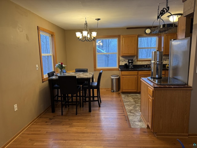 kitchen featuring a notable chandelier, stainless steel fridge, decorative light fixtures, a breakfast bar area, and a kitchen island