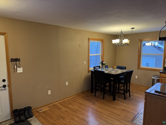 dining area with an inviting chandelier and hardwood / wood-style flooring