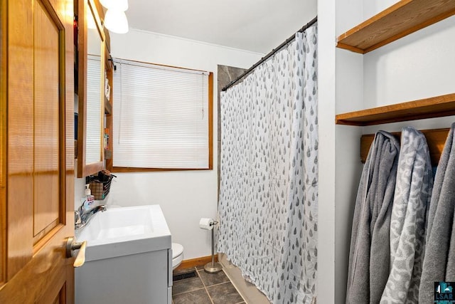 bathroom featuring tile patterned floors, toilet, vanity, and walk in shower