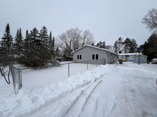 view of snow covered exterior with a shed