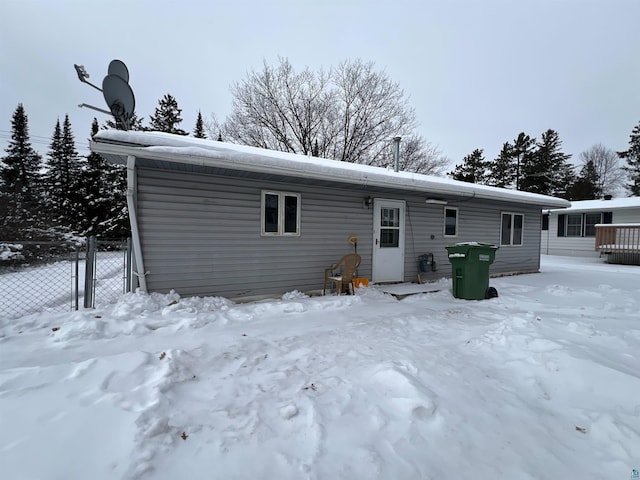 view of snow covered back of property