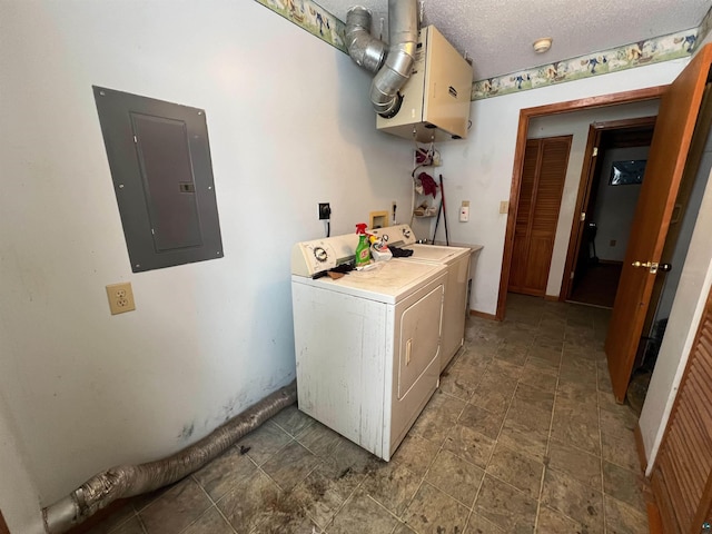 washroom with cabinets, a textured ceiling, washing machine and dryer, and electric panel