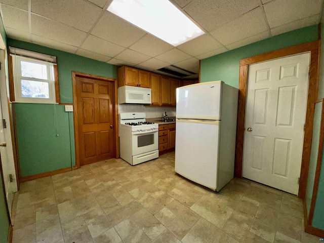 kitchen featuring a drop ceiling and white appliances