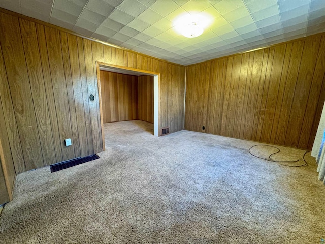 carpeted empty room with wooden walls