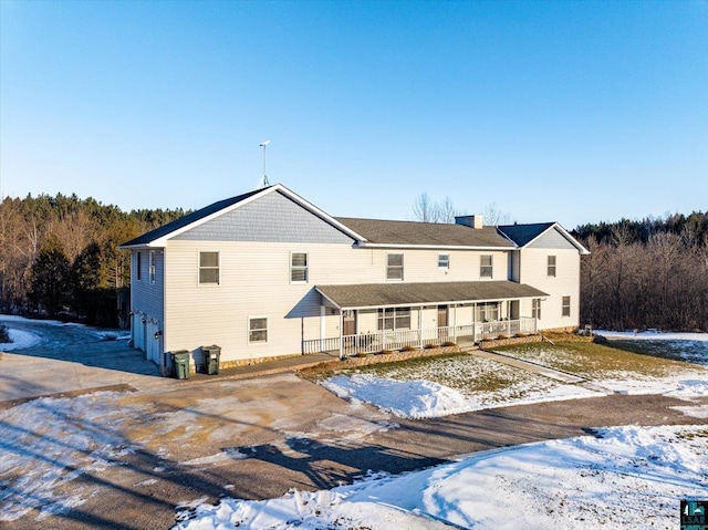 snow covered property with covered porch