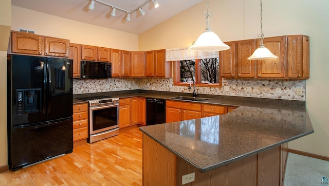 kitchen featuring decorative backsplash, kitchen peninsula, sink, black appliances, and hanging light fixtures