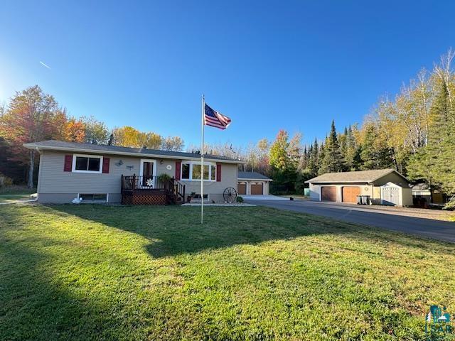 single story home with an outbuilding and a front lawn