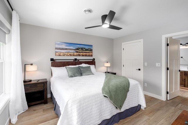 bedroom featuring ensuite bathroom, light hardwood / wood-style flooring, and ceiling fan