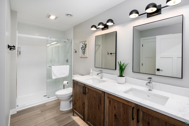 bathroom featuring hardwood / wood-style floors, vanity, an enclosed shower, and toilet