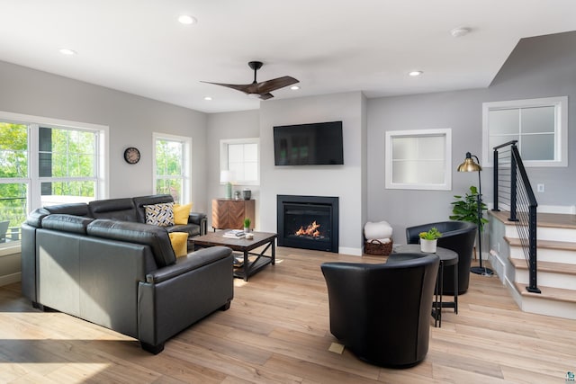 living room with light hardwood / wood-style floors and ceiling fan