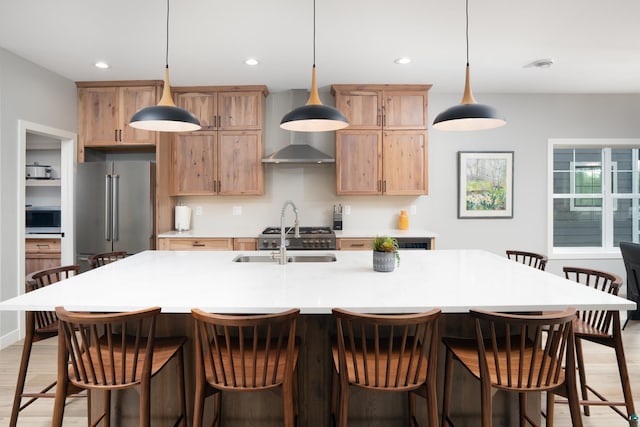 kitchen with a breakfast bar, stainless steel appliances, a spacious island, sink, and hanging light fixtures