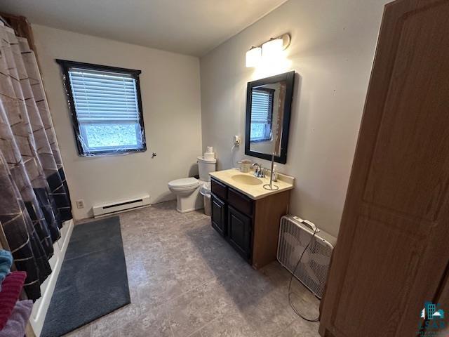 bathroom with vanity, toilet, radiator heating unit, and baseboard heating