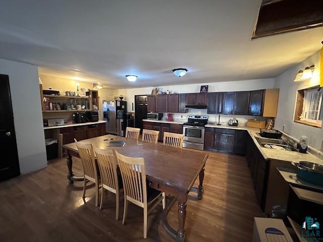 kitchen featuring dark brown cabinetry, dark hardwood / wood-style floors, and appliances with stainless steel finishes