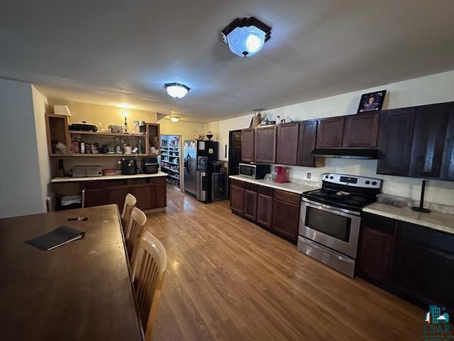 kitchen with dark brown cabinets, stainless steel appliances, and light hardwood / wood-style flooring