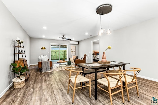 dining area with ceiling fan, wood-type flooring, and a wall unit AC