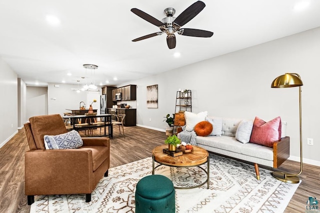 living room featuring hardwood / wood-style floors and ceiling fan