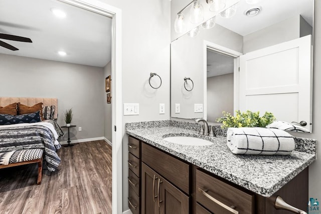 bathroom with hardwood / wood-style floors, ceiling fan, and vanity