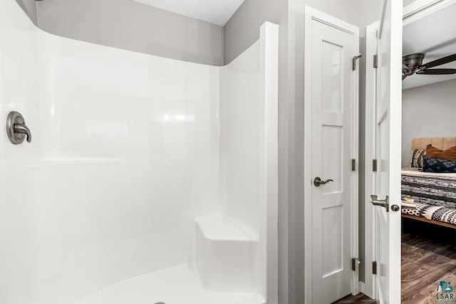 bathroom featuring ceiling fan, hardwood / wood-style floors, and a shower