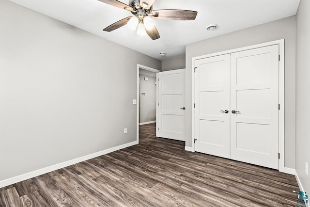 unfurnished bedroom featuring ceiling fan, dark hardwood / wood-style floors, and a closet