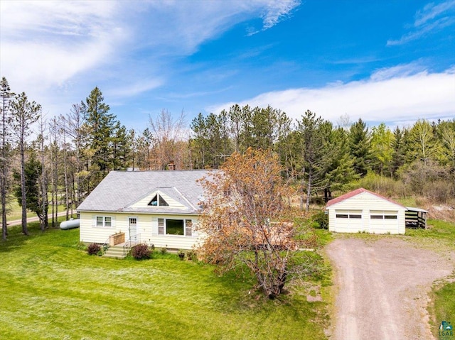 view of front of property with a garage, an outbuilding, and a front yard