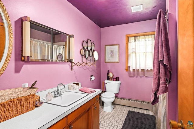 bathroom featuring vanity, toilet, and a baseboard heating unit