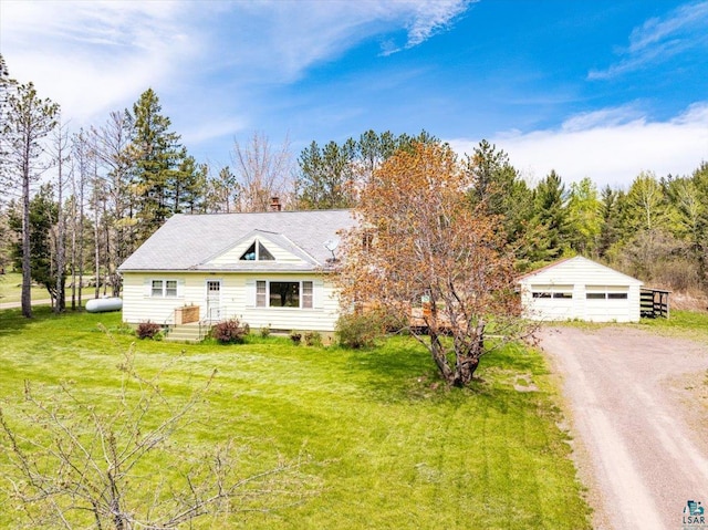 view of front of property with a garage, an outdoor structure, and a front yard