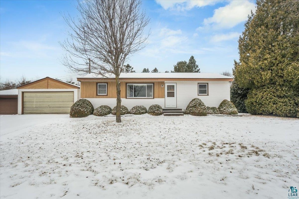 single story home featuring a garage and an outbuilding