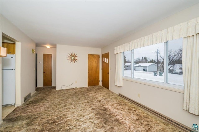 carpeted empty room with baseboard heating