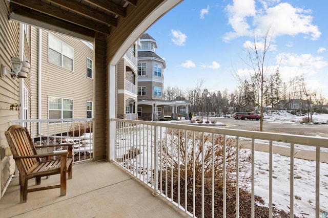 snow covered back of property featuring a porch