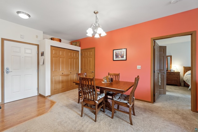 dining space featuring light colored carpet and a chandelier