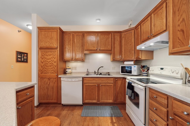 kitchen featuring sink, white appliances, and light wood-type flooring