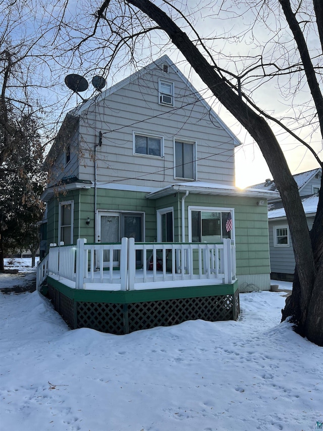 snow covered house with a deck