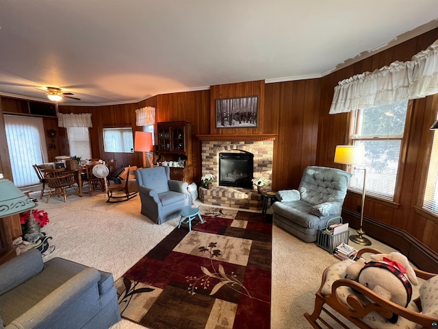 living room with ceiling fan, a fireplace, dark carpet, and wood walls