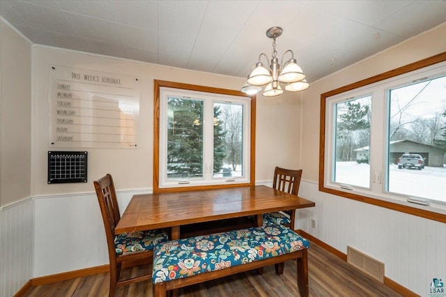 dining space with plenty of natural light, dark hardwood / wood-style floors, crown molding, and a chandelier