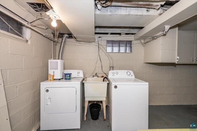 clothes washing area with washing machine and dryer and sink