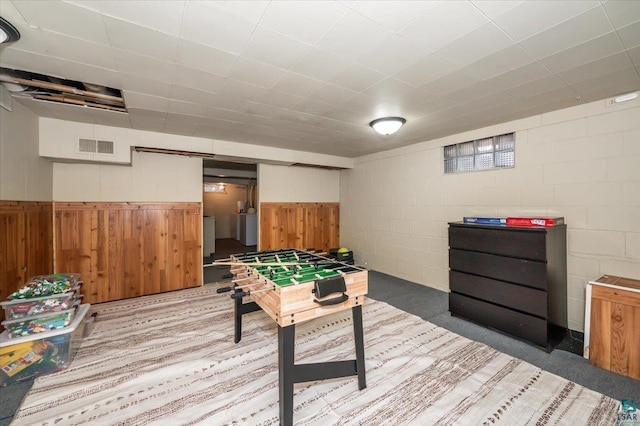 playroom featuring washer / clothes dryer and wooden walls