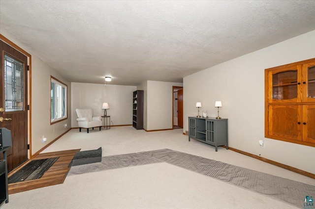 living area featuring a textured ceiling and light carpet