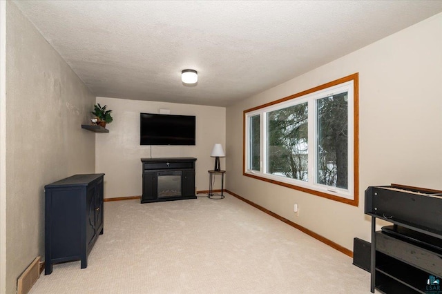 sitting room featuring a textured ceiling, a fireplace, and light carpet