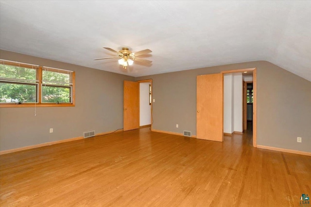 empty room featuring hardwood / wood-style flooring, vaulted ceiling, and ceiling fan