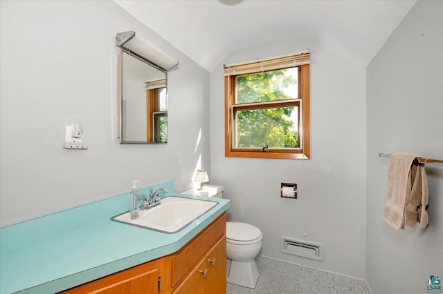 bathroom with vanity, toilet, and lofted ceiling