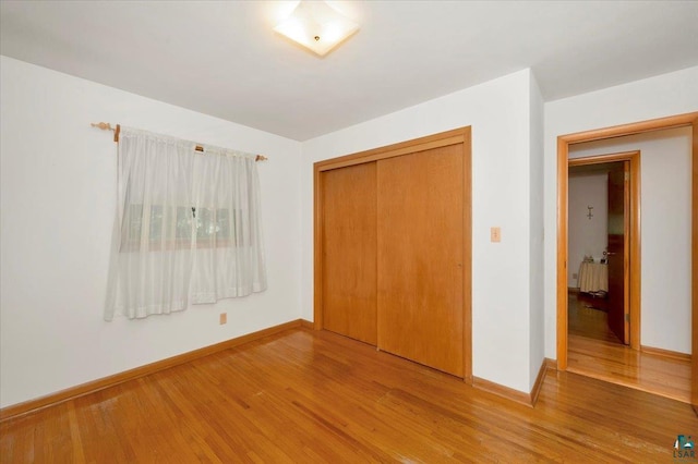 unfurnished bedroom featuring wood-type flooring and a closet