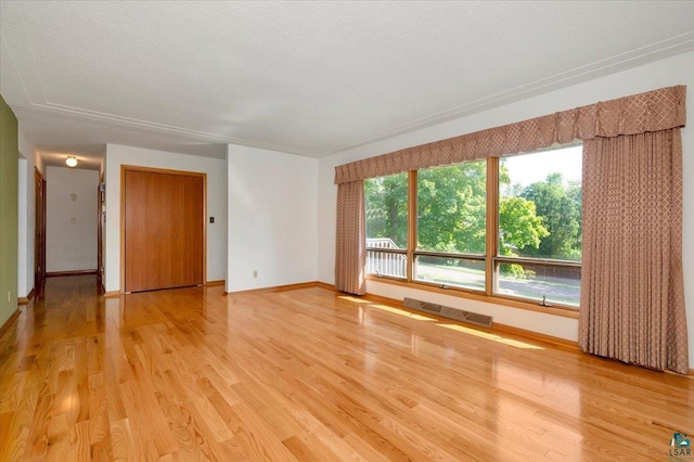 unfurnished room with hardwood / wood-style flooring and a textured ceiling