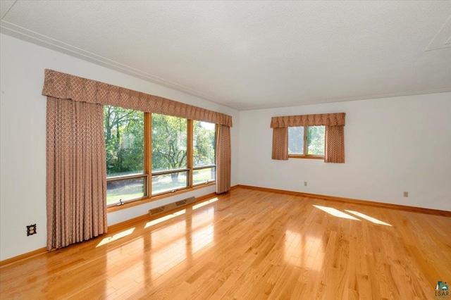 spare room featuring hardwood / wood-style floors and a textured ceiling