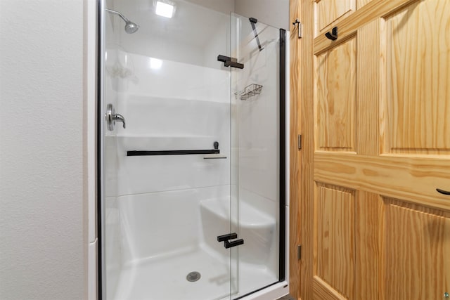 bathroom with a shower with door