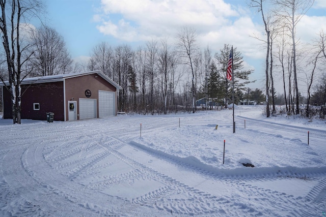 snowy yard featuring a garage