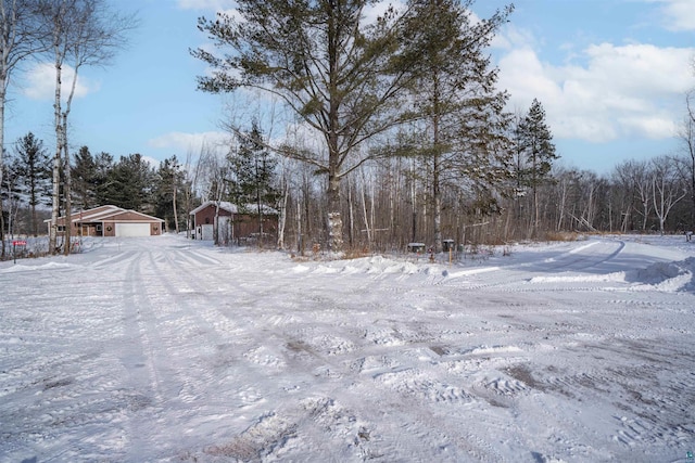 snowy yard with an outbuilding and a garage