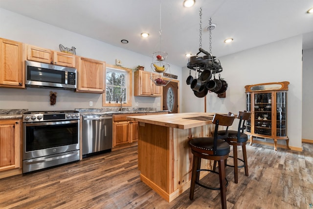 kitchen with a center island, sink, dark hardwood / wood-style floors, butcher block countertops, and stainless steel appliances