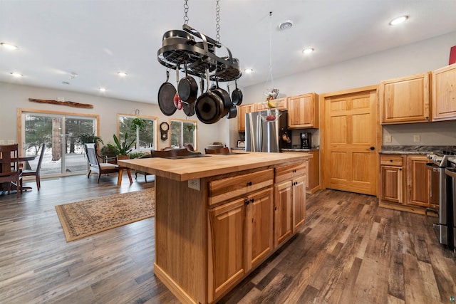 kitchen featuring butcher block countertops, a kitchen island, dark hardwood / wood-style flooring, and appliances with stainless steel finishes