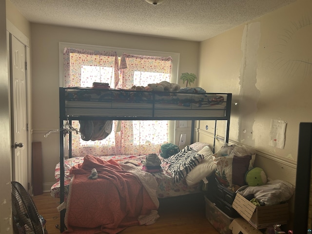 bedroom with a textured ceiling and hardwood / wood-style flooring