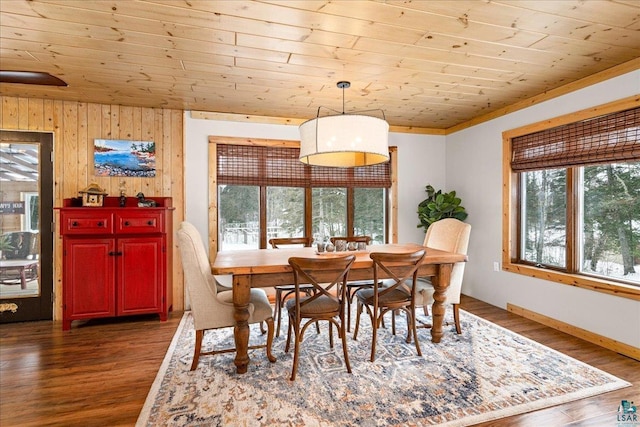 dining room featuring dark hardwood / wood-style flooring, wood walls, ornamental molding, and wood ceiling